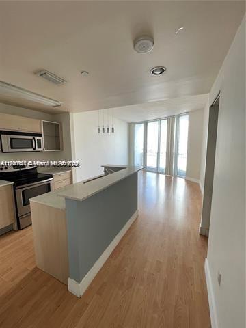 kitchen with a center island, appliances with stainless steel finishes, and light hardwood / wood-style floors