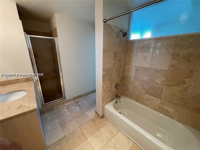 bathroom with shower with separate bathtub, tile patterned flooring, and vanity