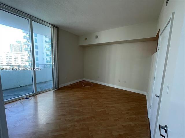 spare room featuring dark wood-type flooring and a wall of windows