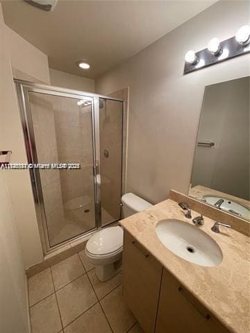 bathroom featuring vanity, tile patterned flooring, toilet, and walk in shower