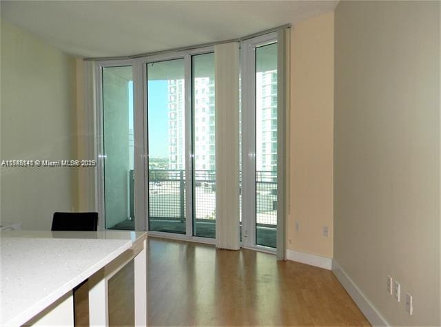 interior space with a wall of windows, a healthy amount of sunlight, and hardwood / wood-style floors