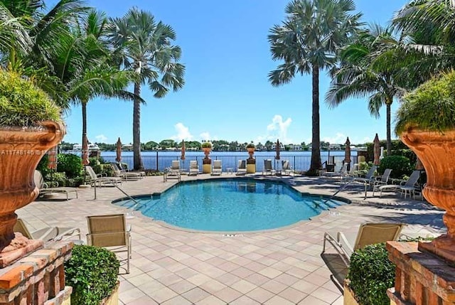 view of pool with a water view and a patio