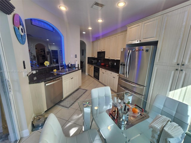 kitchen featuring light tile patterned floors, sink, black appliances, light brown cabinets, and tasteful backsplash