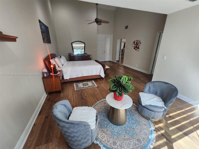 bedroom featuring dark wood-type flooring, a closet, and a towering ceiling