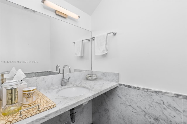 211 Water Way Unit 211, Miami Beach, FL 33141 - bathroom featuring tile walls, lofted ceiling, and a sink