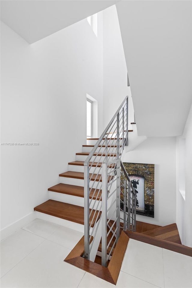 211 Water Way Unit 211, Miami Beach, FL 33141 - stairway with baseboards, a high ceiling, and tile patterned floors