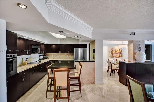 19667 Turnberry Way Unit 12F, Aventura, FL 33180 - kitchen featuring crown molding, a raised ceiling, and appliances with stainless steel finishes