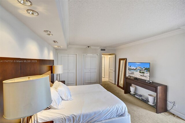 19667 Turnberry Way Unit 12F, Aventura, FL 33180 - carpeted bedroom with a textured ceiling, multiple closets, ornamental molding, and visible vents