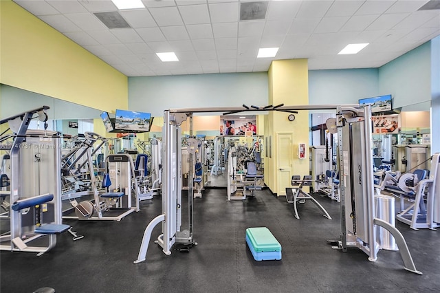 exercise room featuring a high ceiling and a paneled ceiling