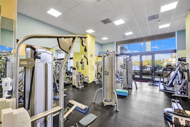 workout area with a high ceiling and a paneled ceiling