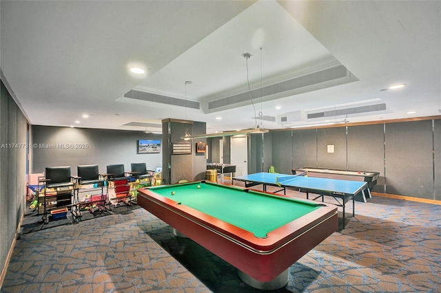 game room with pool table, a tray ceiling, recessed lighting, and stone finish flooring