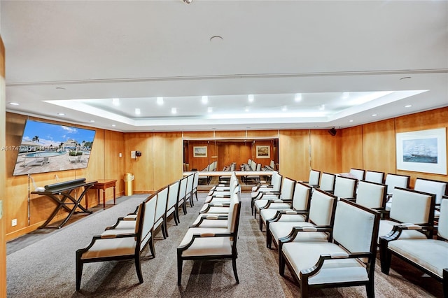 carpeted cinema with wooden walls, a tray ceiling, and recessed lighting