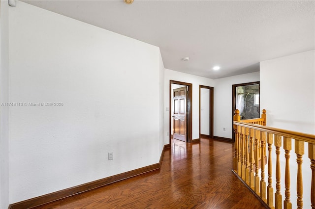 corridor with wood finished floors and baseboards