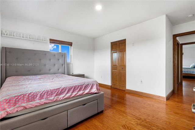 bedroom featuring visible vents, baseboards, and wood finished floors
