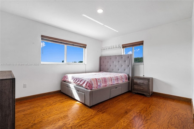 bedroom with visible vents, baseboards, and wood finished floors