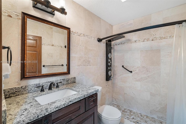 bathroom featuring a textured ceiling, toilet, vanity, tile walls, and a shower stall