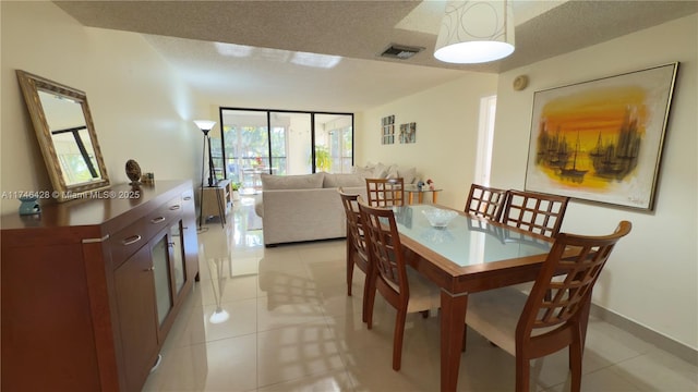 dining room featuring visible vents, a textured ceiling, and light tile patterned flooring