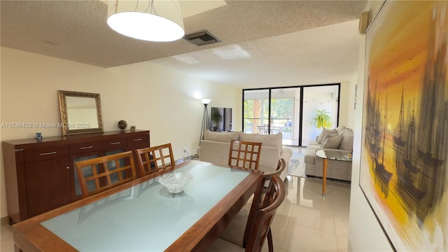 tiled dining area with a textured ceiling and a wall of windows