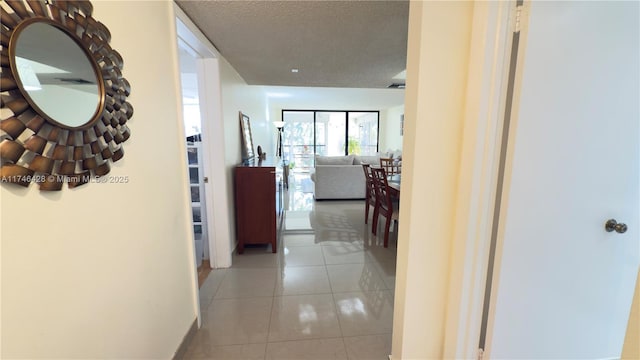 corridor with light tile patterned floors and a textured ceiling