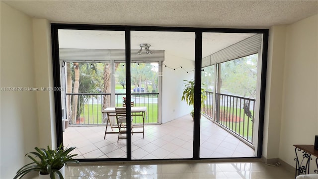 doorway to outside featuring tile patterned flooring, floor to ceiling windows, a textured ceiling, and baseboards