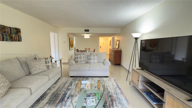 living area with visible vents and a textured ceiling