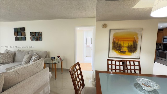 dining space featuring light tile patterned flooring, baseboards, and a textured ceiling