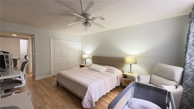 bedroom featuring light wood-style flooring, a textured ceiling, a closet, baseboards, and ceiling fan