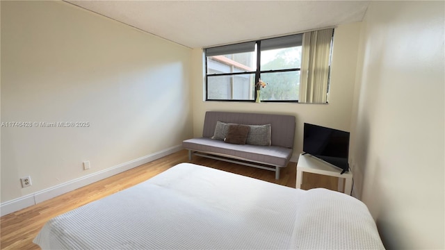 bedroom with baseboards and wood finished floors