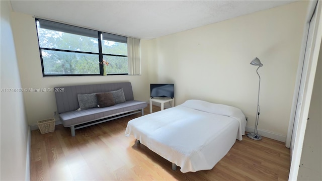 bedroom featuring baseboards and light wood finished floors