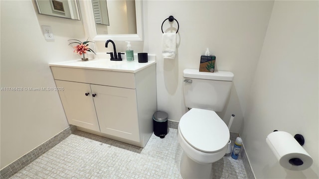 bathroom featuring vanity, toilet, and baseboards