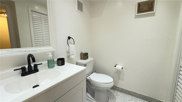 half bath with tile patterned flooring, visible vents, toilet, and vanity
