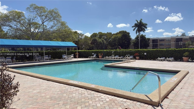 pool with a patio and fence