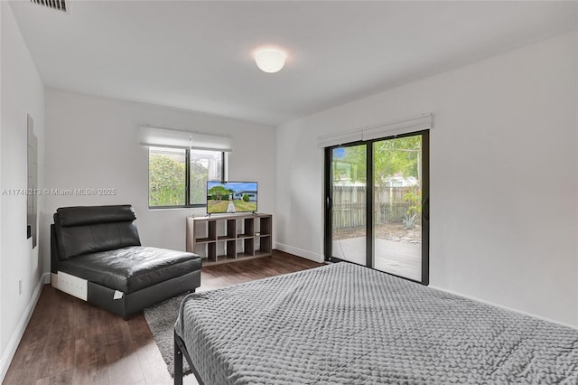 bedroom with dark hardwood / wood-style flooring, access to outside, and multiple windows