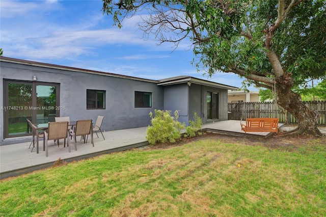 rear view of property with a deck and a lawn