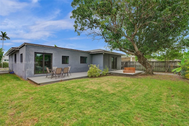 rear view of house with a patio and a yard