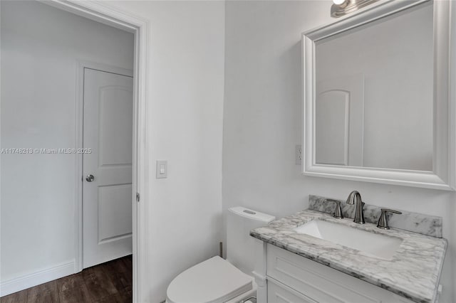 bathroom featuring toilet, hardwood / wood-style flooring, and vanity