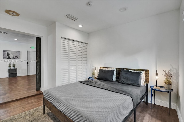 bedroom with dark wood-type flooring and a closet