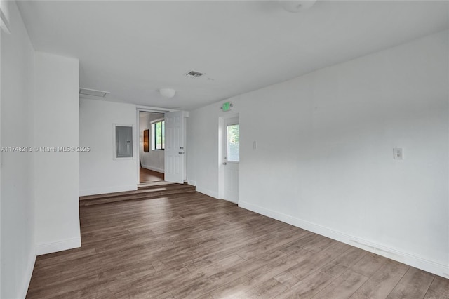 unfurnished room featuring hardwood / wood-style flooring and electric panel