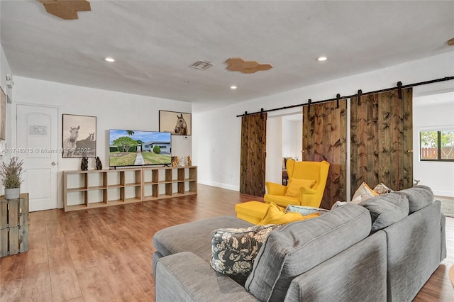 living room with hardwood / wood-style flooring and a barn door