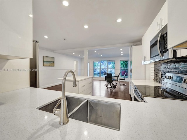 4721 W Park Rd, Hollywood, FL 33021 - kitchen featuring appliances with stainless steel finishes, a sink, white cabinets, decorative backsplash, and recessed lighting