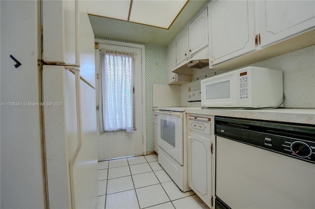 kitchen with light tile patterned flooring, white appliances, and white cabinetry