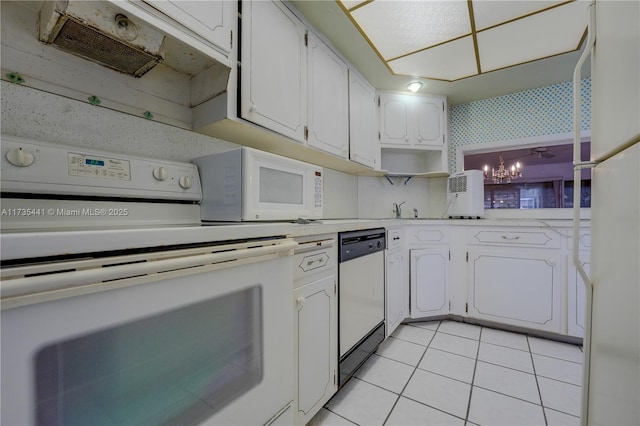 kitchen with white appliances, an inviting chandelier, light tile patterned flooring, range hood, and white cabinets