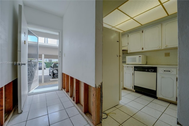 kitchen featuring white appliances, light tile patterned floors, and white cabinetry