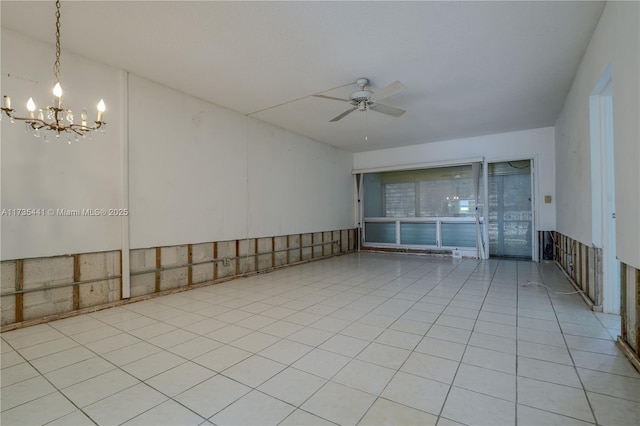 unfurnished room with ceiling fan with notable chandelier and light tile patterned flooring
