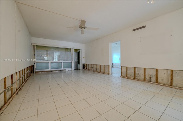 tiled spare room with ceiling fan