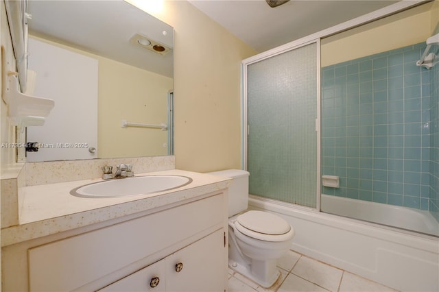 full bathroom with tile patterned flooring, bath / shower combo with glass door, vanity, and toilet
