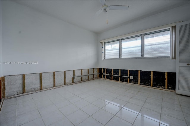 empty room featuring ceiling fan and lofted ceiling