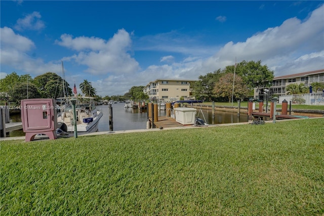 view of dock featuring a lawn and a water view