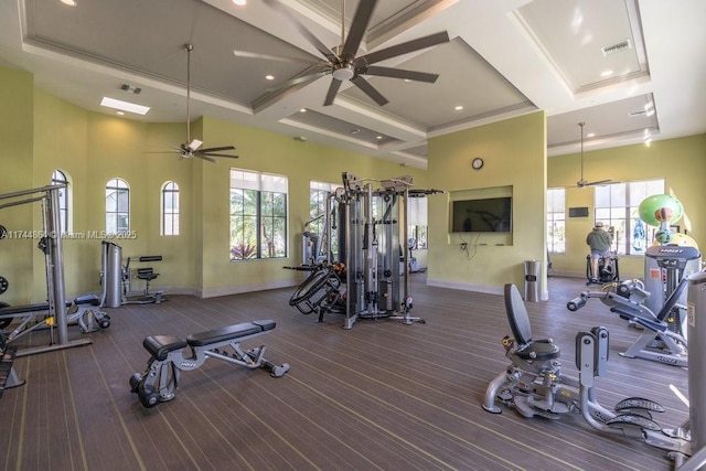 workout area featuring a towering ceiling, crown molding, ceiling fan, and coffered ceiling