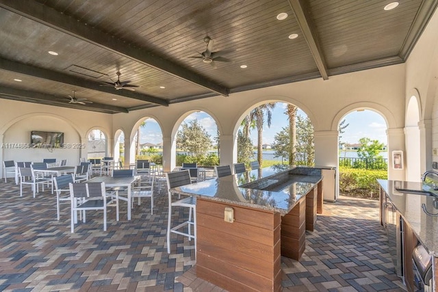 view of patio with an outdoor bar and ceiling fan